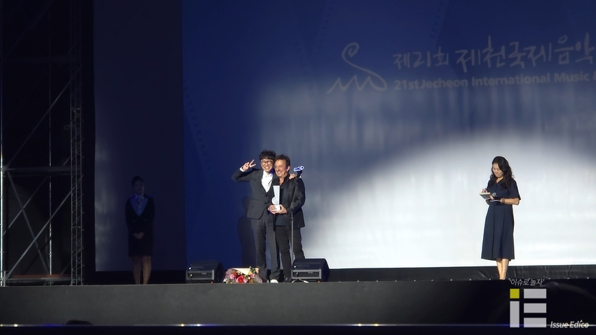 4일 오후 7시 제천비행장 돔 특설무대에서 열린 올해 짐프 개막식에서 제천영화음악상을 수상한 에릭 세라와 장항준 집행위원장이 기념사진을 찍고 있다. 
